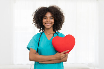 Portrait of smiling young female doctor or young nurse wearing blue scrubs uniform and stethoscope...