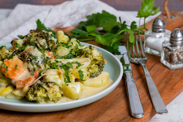 Tasty broccoli casserole served on the plate on the cutting board and textile.