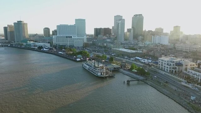 New Orleans Cityscape during French Quarters Music Festival, Louisiana. Steamboat Natchez Mississippi River City Skyline in Background. Sunset Light