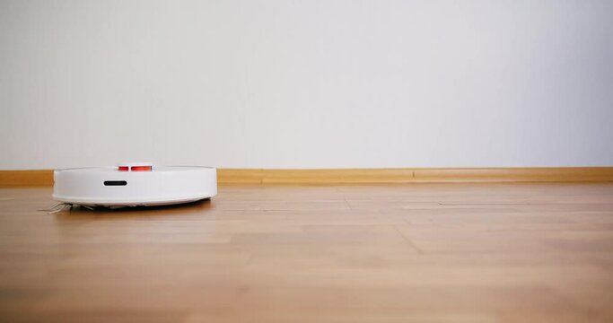 Robot vacuum cleaner performs automatic cleaning of the house at a certain time. Smart home concept. Copy space