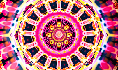 A close-up of a kaleidoscopic mandala, featuring intricate geometric patterns in shades of pink, blue, and yellow