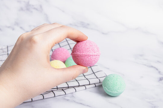 Pink, Green And Yellow Bath Bombs On Marble Background. Bath Salts. Woman Holds Pink Bath Bomb