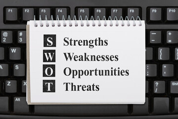 SWOT analysis message on a notepad on a computer keyboard