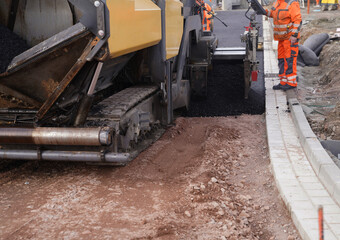Asphalting of a new road on a construction site housing construc