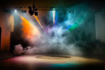 stage for performances illuminated by spotlights in multi-colored smoke