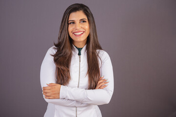 Horizontal photo. brazilian woman with medical coat, nutritionist. with arms crossed.