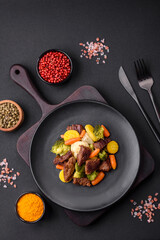 Delicious fresh beef and vegetables carrots, broccoli, cauliflower on a black plate
