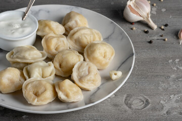 Traditional russian pelmeni, ravioli, dumplings with meat on a wooden table