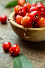 Fresh cherries with leaves in a wooden bowl