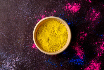 top view of colorful traditional holi powder in bowls isolated on dark background.Space for text . happy holi.Concept Indian color festival called Holi