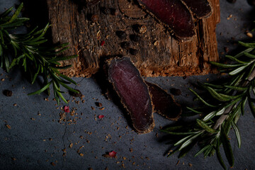 several pieces of thinly sliced ​​dried meat with spices and herbs