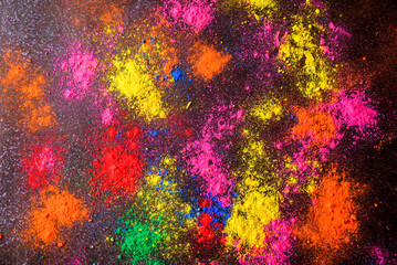 top view of colorful traditional holi powder in bowls isolated on dark background.Space for text . happy holi.Concept Indian color festival called Holi