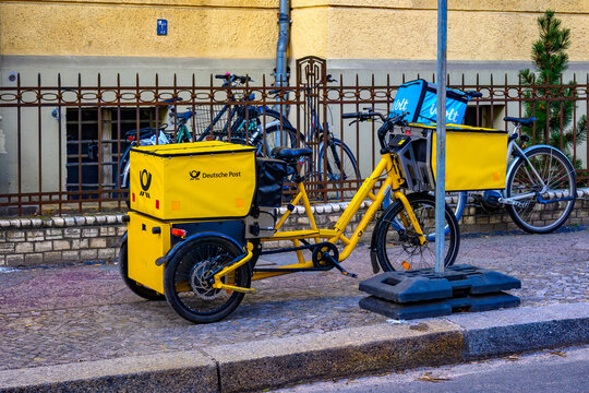 Berlin, Germany - February 9, 2023: Electric tricycle from the company Deutsche Post on a sidewalk in Berlin.