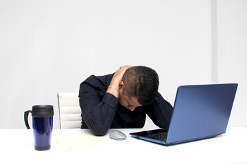 Latino adult man works in his office with his laptop, his head, neck, and back, cervical, lumbar...