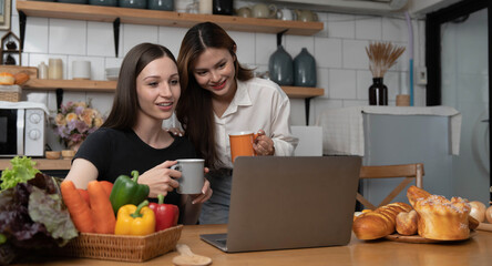 Female and female or LGBT couples are happily cooking bread together with happy smiling face in kitchen at home