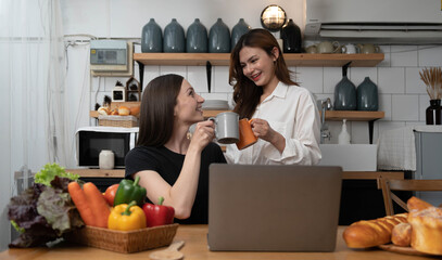Female and female or LGBT couples are happily cooking bread together with happy smiling face in kitchen at home