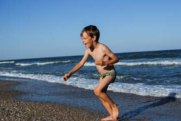 Fototapeta na wymiar child playing on the ocean seashore