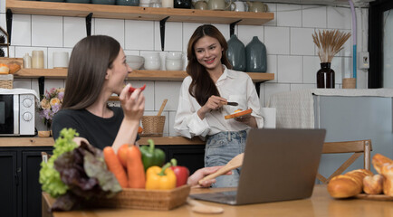 Female and female or LGBT couples are happily cooking bread together with happy smiling face in kitchen at home