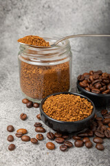 Ingredients for making coffee - coffee beans, ground and instant coffee on a black textured background. Caffeine. Decaffeinated coffee. Aroma energy hot drink. Place for text, space for copy.