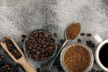 Ingredients for making coffee - coffee beans, ground and instant coffee on a black textured background. Caffeine. Decaffeinated coffee. Aroma energy hot drink. Place for text, space for copy.