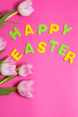 beautiful tulips flowers and word Happy Easter on pink background