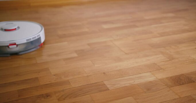 Robot vacuum cleaner performs automatic cleaning of the house at a certain time. Smart home concept. Copy space