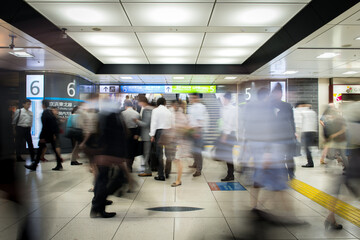 Busy train station in Tokyo with commuters in motion