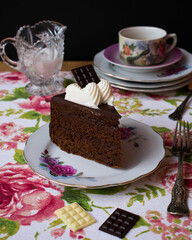 Porción de tarta típica de Austria con bizcocho de chocolate relleno de mermelada, decoración vintage.