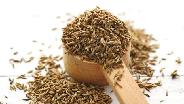 cumin seeds on spoon on table , close up 