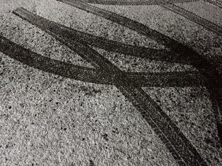 First snowfall: tire tracks on snowy asphalt road