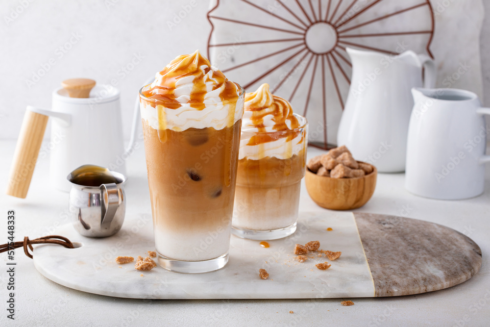 Wall mural Iced caramel latte in a tall glass with drips of caramel sauce