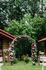 Outdoor wedding ceremony setup, wedding arch decorated with pastel white flowers