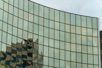 Row of shimmering glass pannels on side of modern office building in downtown city in urban...