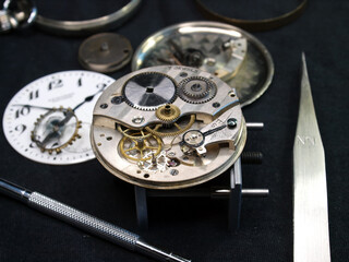 watchmaker work bench: vintage watch mechanism dissasembled and watch tools