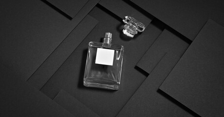 Mockup of glass perfume bottle on a dark multi-layered black background. Background for perfume...