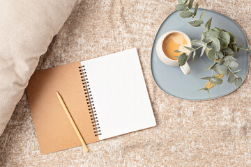 Mockup of notebook and coffee cup on beige plaid background, with copy space for text. Flat lay, top view photo mock up.