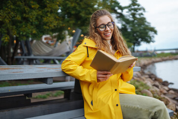 Young  woman reading a book in the park. Relaxation, enjoying, solitude with nature.