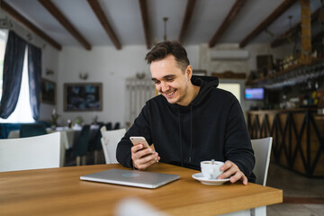 Fototapeta premium one man use mobile phone while sit at the table at restaurant