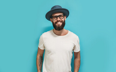 Young bearded hipster guy wearing white blank t shirt with copy space for your text or logo. Mockup for design