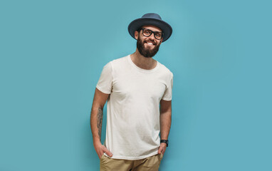 Young bearded hipster guy wearing white blank t shirt with copy space for your text or logo. Mockup...