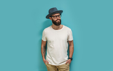 Young bearded hipster guy wearing white blank t shirt with copy space for your text or logo. Mockup for design