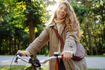 Fototapeta na wymiar Beautiful woman riding bicycle in park. Lifestyle. Relax, nature concept. Spring time.