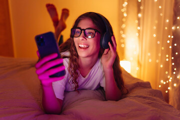 Young woman in headphones listening music and chatting. Lifestyle, relax, technology concept.