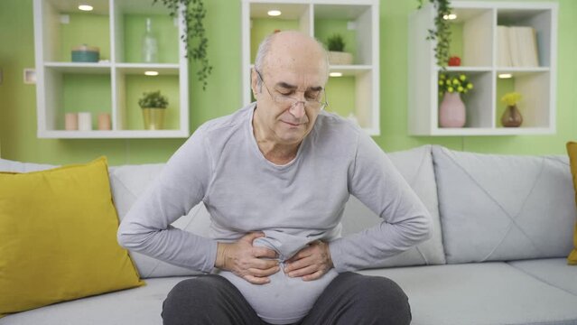 Old man with pancreatic cancer at home with stomach ache, writhing in pain.
Old man with stomach ache and suffering has pancreatic cancer.
