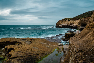 Fototapeta na wymiar Standing on cliff overlooking looking the ocean on a cloudy day - Pacific Ocean - San Diego Cliffs
