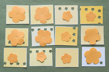 large paper florals on yellow paper tiles with paint-chip coloration - some with star cutouts