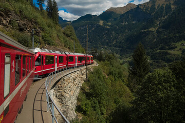 Train of Rhaetian Railway riding in a mountain landscape in canton Graubünden, South-East Switzerland