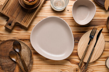 Beautiful table setting with plates, bowl and cutlery on wooden background