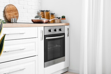 Modern electric oven in interior of light kitchen