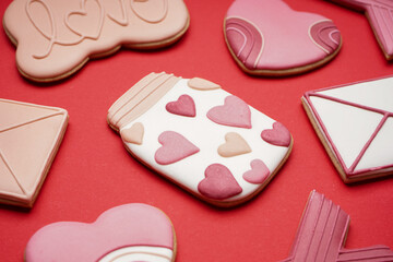 Different sweet cookies for Valentine's Day celebration on red background, closeup